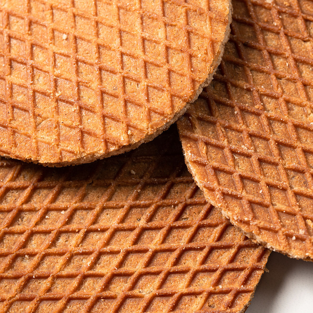 A group of Authentic Red Stroopwafel Tin Cans by Wonderen Stroopwafels on a white plate.